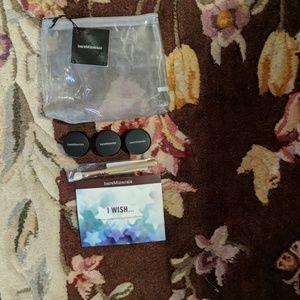Three eyeshadows, eyeshadow brush, and makeup bag
